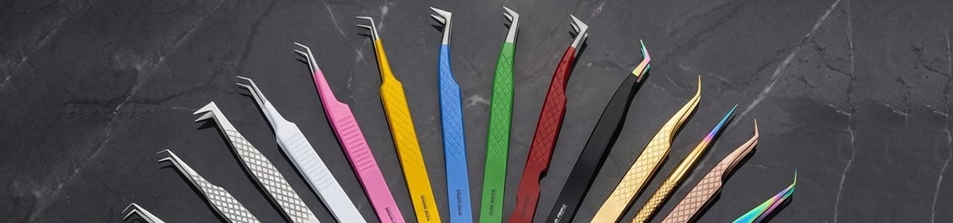 Professional stainless steel eyelash extension tweezers collection featuring volume and isolation tips in gold and plasma finishes displayed on marble for wholesale